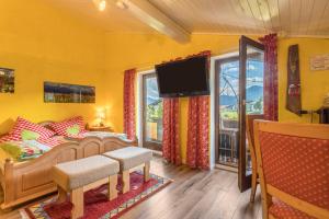 gelbes Zimmer mit einem Bett, einem TV und einem Fenster in der Unterkunft Zwischen Chiemsee und Bergen Dg in Bernau am Chiemsee