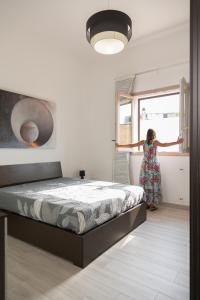 a woman is looking out the window of a bedroom at InCanti Salentini Apartments in Surbo