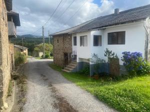 a small white house on a dirt road at Casa Laureano in Carcedo