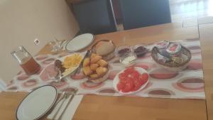 a table with plates and bowls of fruit on it at Apartments Crvena Jabuka in Ključ