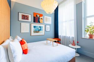 Un dormitorio con una cama con una pared azul. en Vie Via - Your Hotel, en Leeuwarden
