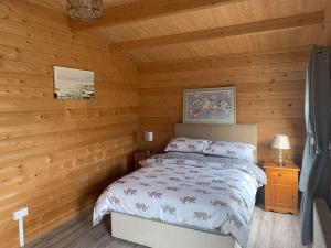 a bedroom with a bed in a log cabin at Cheerful Cozy Cabin in Countryside in Limerick