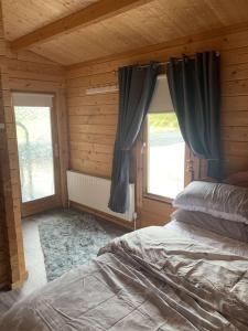 a bedroom with a bed and a window with curtains at Cheerful Cozy Cabin in Countryside in Limerick