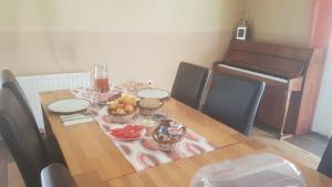 mesa de comedor con fruta y piano en Apartments Crvena Jabuka en Ključ