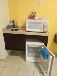 a kitchen counter with a microwave on top of it at City Bauru Reserve Agora in Bauru