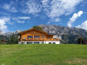 dom w polu z górami w tle w obiekcie Appartements Die Ramsauerin w mieście Ramsau am Dachstein