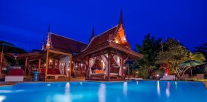 ラワイビーチにあるRoyal Thai Villa Phuket - SHA Extra Plusの夜間のスイミングプール付きのヴィラ