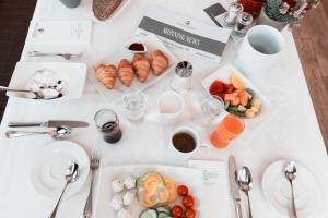 uma mesa branca com pratos de comida em Hotel Steiner Superior em Obertauern