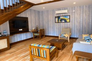 Sandbanks Beach Villas, Morjim في مورجيم: غرفة معيشة مع أريكة وتلفزيون