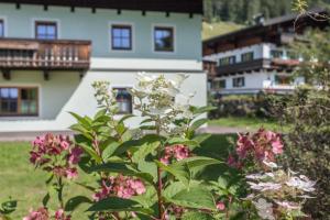 um arbusto de flores em frente a uma casa em Ferienwohnung Jägermeister em Sankt Martin bei Lofer