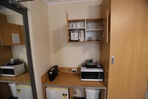 a room with a kitchen with a counter with a microwave at Townhouse Motel Cowra in Cowra