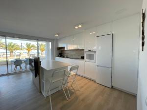 a kitchen with white cabinets and a table and chairs at Oropesa del Mar, Playa Morro de Gos, Playa Blanca in Oropesa del Mar