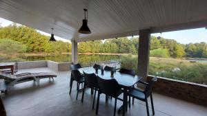 a table and chairs on a patio with a view of a river at Lake House in Dullstroom