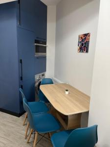 a dining room with a wooden table and blue chairs at Iulius Mall River Tower in Iaşi