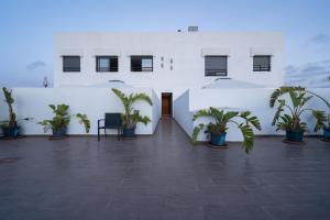 a courtyard with potted plants in a white building at La cascade de Maryline in Casablanca