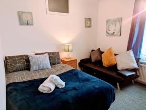 - une chambre avec un lit et un canapé dans l'établissement Gillings Villa -5 Bed Great For Long & Short Stay!!! Gillingham Kent, à Hoo