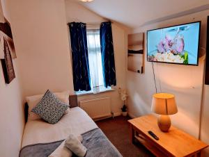 ein Wohnzimmer mit einem Sofa und einem TV an der Wand in der Unterkunft Gillings Villa -5 Bed Great For Long & Short Stay!!! Gillingham Kent in Hoo