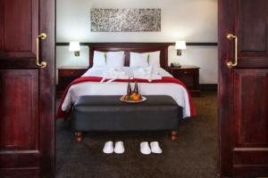 Habitación de hotel con cama y bandeja de comida en Court Classique Suite Hotel en Pretoria