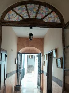 una entrada a un edificio con un techo de vidrieras en La Plazuela, casa andaluza con patio., en Montoro