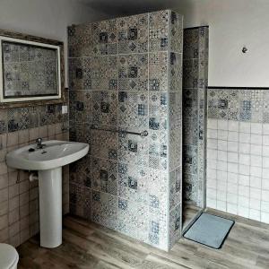 a bathroom with a sink and a shower at La Plazuela, casa andaluza con patio. in Montoro