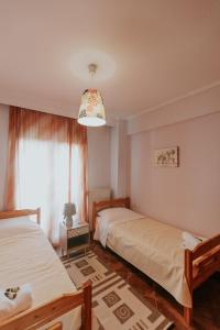 a bedroom with two beds and a chandelier at MARIAM APARTMENT in Thessaloniki