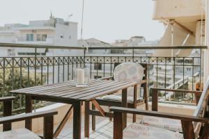 a wooden table and chairs on a balcony at MARIAM APARTMENT in Thessaloniki