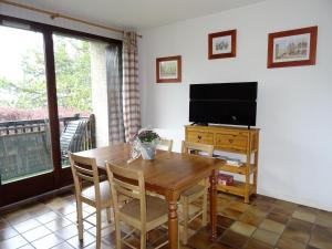 uma sala de jantar com uma mesa e uma televisão em EMBRUN Superbe appartement classé 3 étoiles tout équipé avec vue sur montagnes em Saint-Sauveur