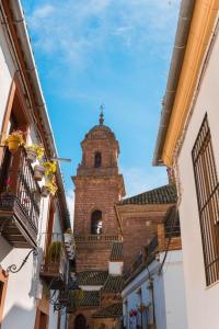 a building with a clock tower on top of it at La Plazuela, casa andaluza con patio. in Montoro