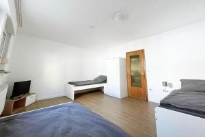 Cette chambre blanche dispose d'un lit et d'une télévision. dans l'établissement Equipped Apartment in Düren, à Düren