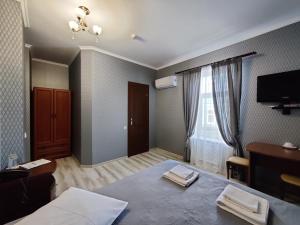 a bedroom with a bed and a desk and a television at Evropeyskiy in Kyiv