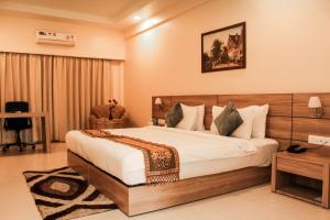 ein Schlafzimmer mit einem großen Bett in einem Zimmer in der Unterkunft Hotel Tea County in Dibrugarh