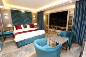 a hotel room with a bed and two chairs at Petra Sella Hotel in Wadi Musa