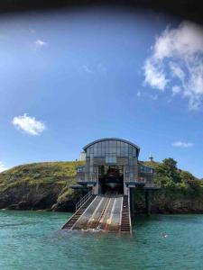 a building sitting on a dock in the water at Lobster Cottage - Stylish 3 Bedroom Cottage in heart of Tenby Town, Pembrokeshire in Pembrokeshire