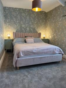 a bedroom with a large bed with two night stands at Lobster Cottage - Stylish 3 Bedroom Cottage in heart of Tenby Town, Pembrokeshire in Pembrokeshire +25 photos