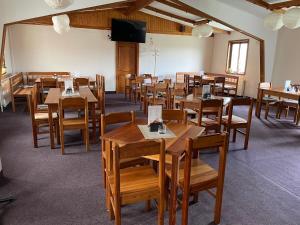 une salle à manger avec des tables et des chaises en bois dans l'établissement Penzion Na Srubech, à Hora Svaté Kateřiny