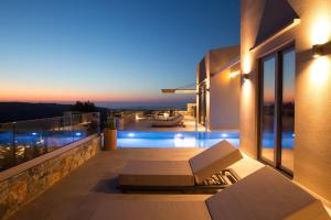 a view from the balcony of a house at night at Eforasis Villas , an intriguing hideaway, by ThinkVilla in Arménoi