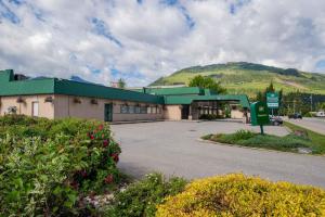 a building with a green roof and a parking lot at Sandman Hotel Revelstoke in Revelstoke