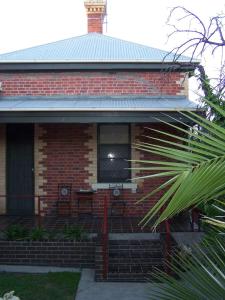 a red brick house with a window and a porch at RJ's Bed & Breakfast in Maryborough