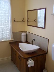 a bathroom with a sink and a mirror at RJ's Bed & Breakfast in Maryborough