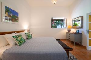 a bedroom with a bed and a dresser and two windows at Finca Botanico Secret Garden in Guatiza