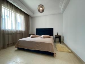 a white bedroom with a bed and a window at Bright Flat Lac 2 Tunis in Tunis