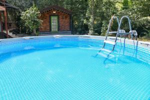 a large swimming pool with twoadders in front of a house at AAA Jermuk rest house in Jermuk