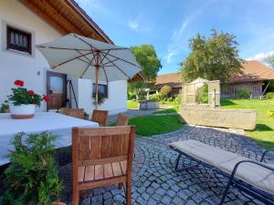 a patio with a table and an umbrella at Ferienwohnungen Anna Altmann in Furth im Wald +8 photos