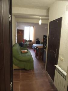 una stanza con ottomana verde in una stanza di Gostevoi dom Batumi. a Batumi