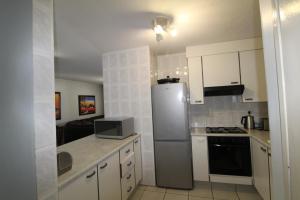 a kitchen with a stainless steel refrigerator and white cabinets at Rondevoux 26 in Margate