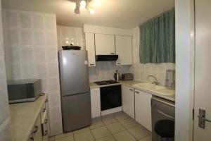 a small kitchen with a refrigerator and a sink at Rondevoux 26 in Margate