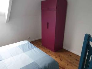 um armário roxo no canto de um quarto em Logements Bonne Nouvelle em Rostrenen