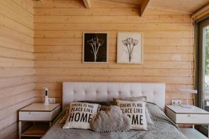 a bedroom with wooden walls and a bed with pillows at Zam-zam apartman in Zamárdi