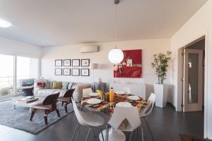 ein weißes Wohnzimmer mit einem Tisch und Stühlen in der Unterkunft Best Houses 38 - Praia Residences in Peniche