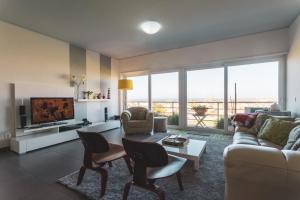 een woonkamer met een bank en een tv bij Best Houses 38 - Praia Residences in Peniche